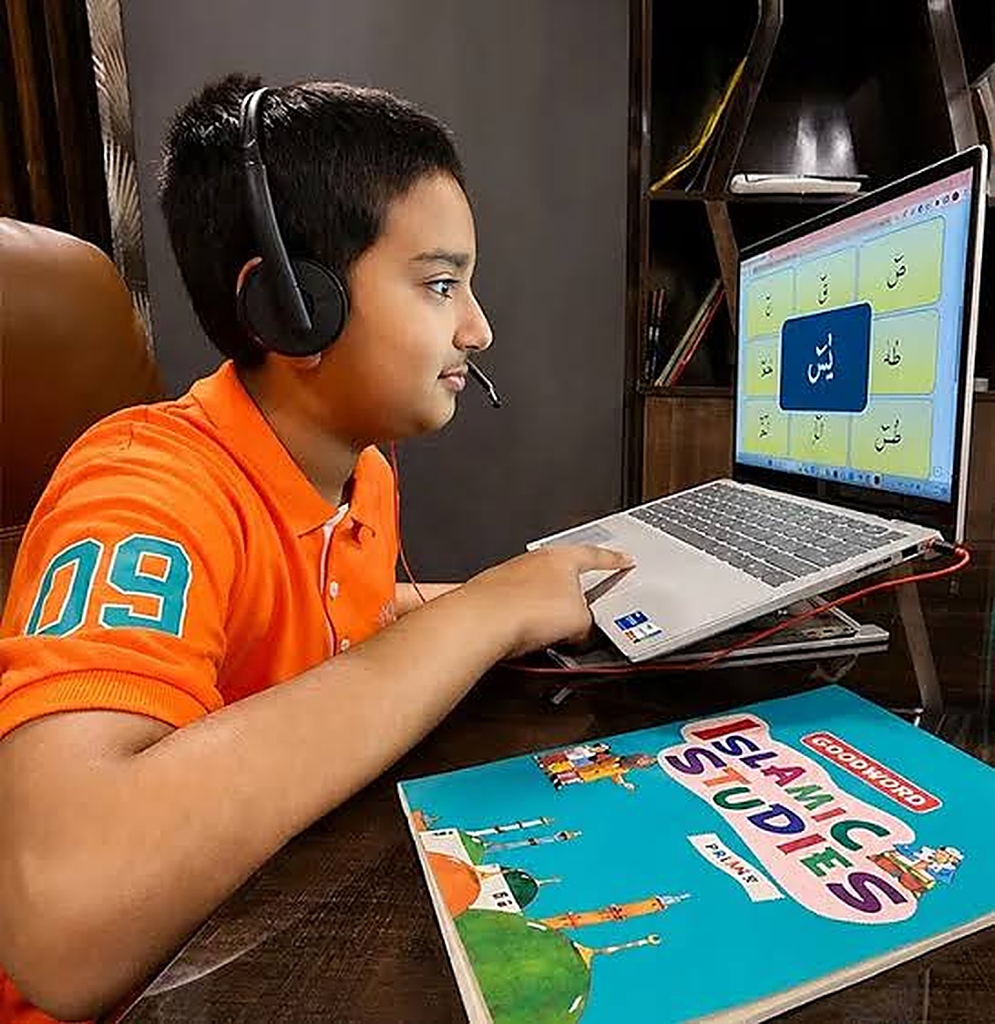 A student wearing a headset learns Arabic letters on a laptop in an online Quran class