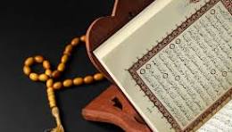 Quran on a wooden stand with prayer beads